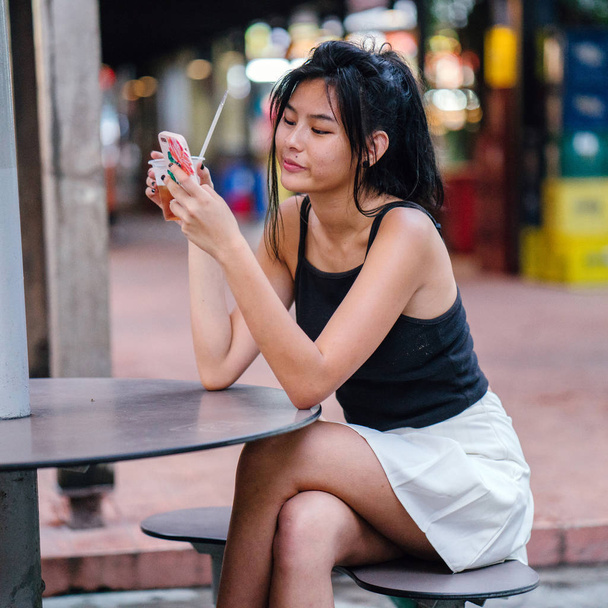 Cute asian girl relaxing in cafe drinking water - Foto, afbeelding