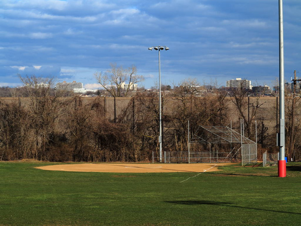 Софтбольное поле - Спортивное место с световыми башнями и живописным голубым небом и clouds.ball Filed
 - Фото, изображение