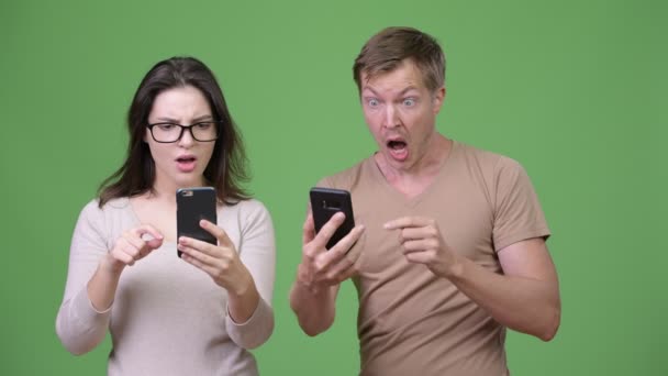 Young couple using phone and getting good news together - Video