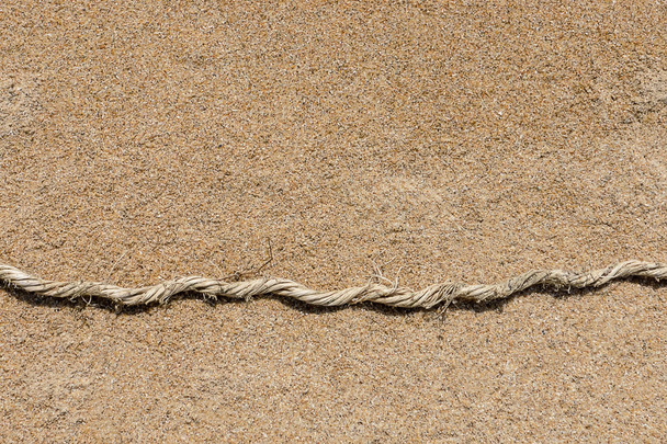 Oud touw op het zand. - Foto, afbeelding