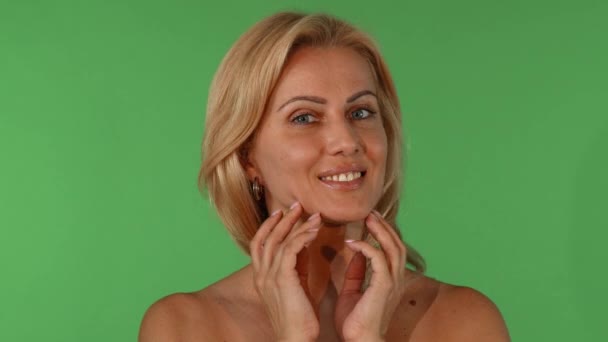 Studio portret van een mooie rijpe vrouw haar gezicht aan te raken sensueel - Video