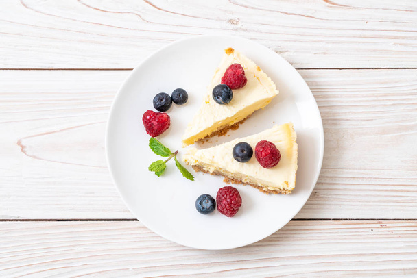 Homemade cheesecake with fresh raspberries and blueberries - Фото, зображення