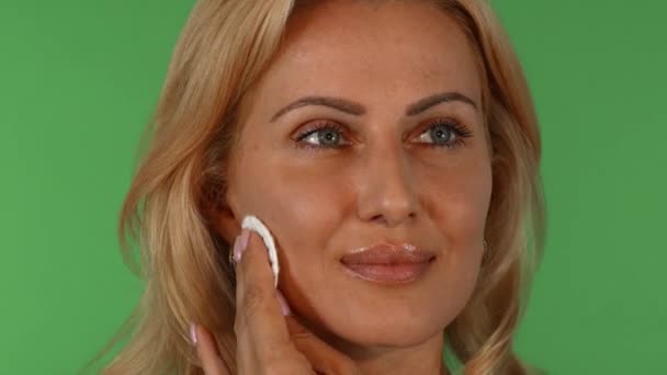 Retrato de una mujer madura impresionante limpiándose la cara con una almohadilla de algodón
 - Imágenes, Vídeo
