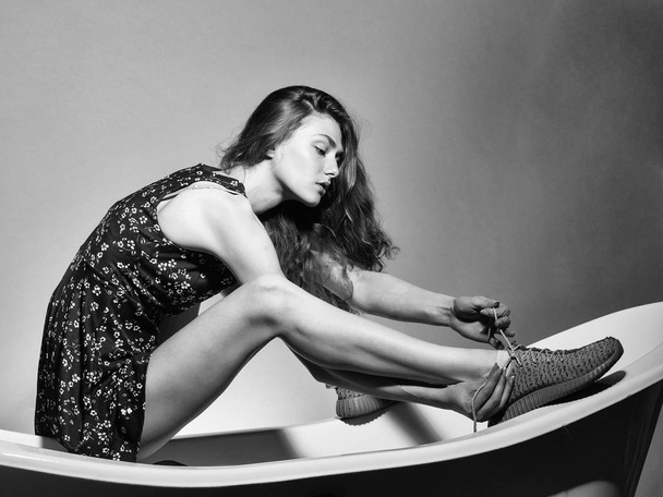 Sensual girl sitting on bathtub. Pretty girl posing on bath - Foto, afbeelding