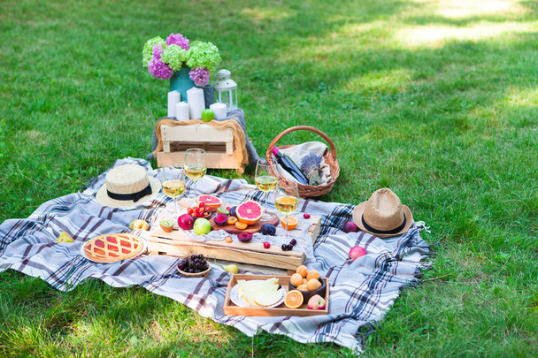 Picnic background with white wine and summer fruits on green grass - Foto, Bild
