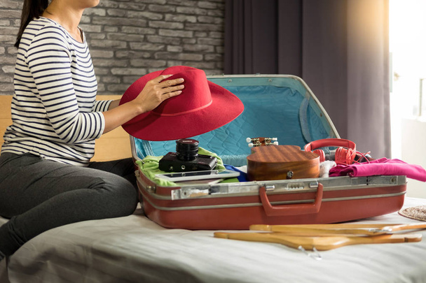 Vrouw hand verpakking een bagage voor een nieuwe reis en reizen voor een lang weekend  - Foto, afbeelding