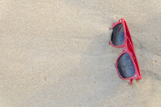 ビーチで赤のサングラス、砂の上に赤いサングラス. - 写真・画像
