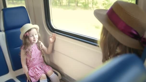 Menina bonito viajando em trem vazio com sua mãe - envia um beijo de ar
 - Filmagem, Vídeo