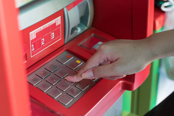 Χέρι πιέστε τους κωδικούς πρόσβασης στο μηχάνημα ΑΤΜ τράπεζας να αποσύρει χρήματα - Φωτογραφία, εικόνα