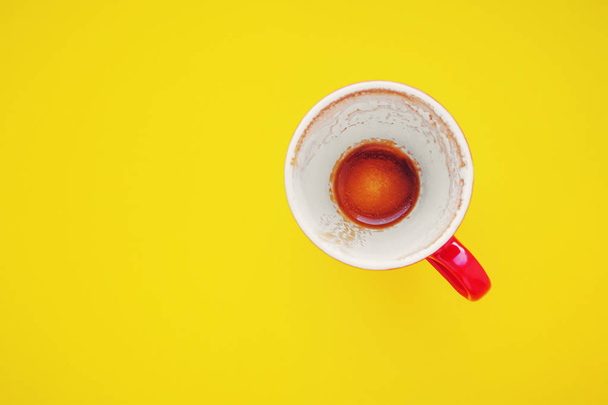 leere rote Tasse nach dem Kaffee auf gelbem Hintergrund - Foto, Bild
