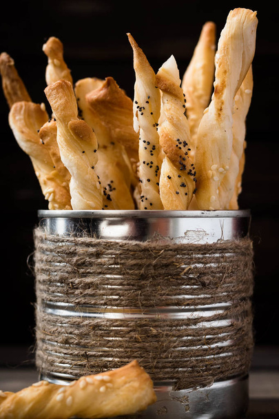 Хлеб палочки с маком семян и кунжута в мишуре деревенский банку на темном фоне
 - Фото, изображение