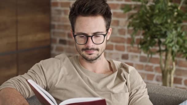 Man reading a book at home office - Felvétel, videó