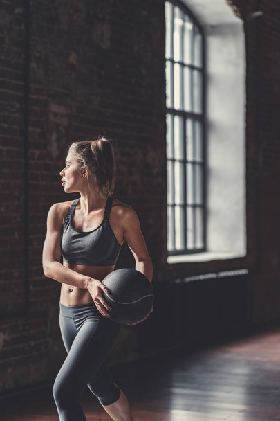 Donna sportiva con una palla nel loft
 - Foto, immagini
