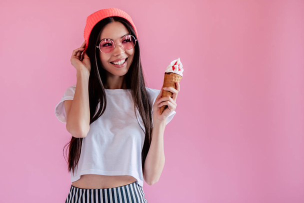 Young asian teenage girl on pink background. Stylish young woman with ice cream isolated. - Fotó, kép