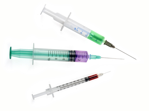 Medizinische Werkzeugspritze mit farbigen Flüssigkeiten isoliert auf weiß - Foto, Bild