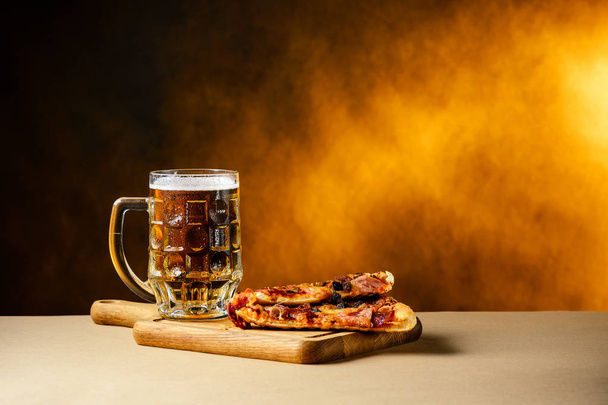 Slice of delicious homemade pizza served with light cold beer on - Foto, Imagen