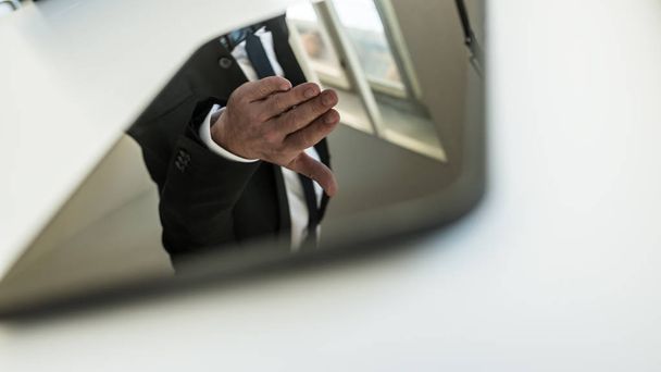 Планшетный компьютер с отражением руки бизнесмена обратился к рукопожатию в офисе
. - Фото, изображение