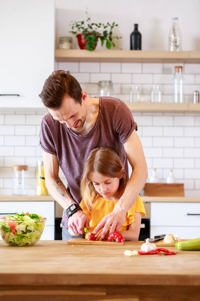 Φωτογραφία του πατέρα του με την μικρή της κόρη μαγείρεμα σαλάτα - Φωτογραφία, εικόνα