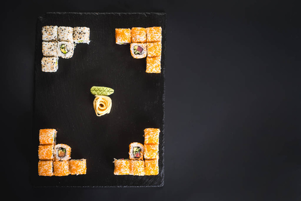A set of different sushi rolls with caviar on black background - Valokuva, kuva