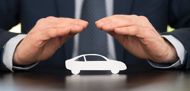 Aseguradora protegiendo un coche con sus manos - Foto, imagen