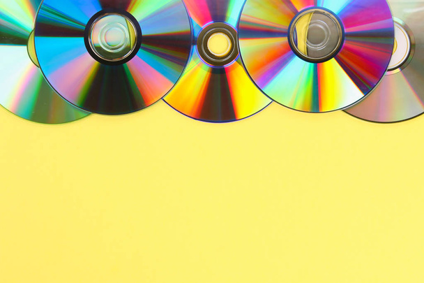 Piles of old and dirty CDs,DVD on pastel background. Used and dusty disk with copy space for add text - Foto, imagen