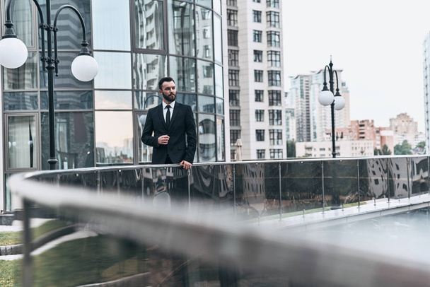young man in suit looking away while standing outdoors - Foto, Imagen