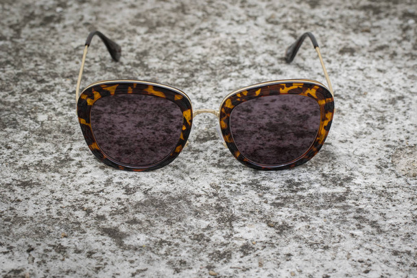 Foto van moderne trendy zonnebril op de grond, glazen. - Foto, afbeelding