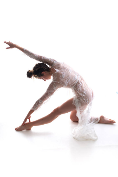 Ψηλός λεπτή μελαχρινή χορεύουν σε μια καθαρή άσπρη δαντέλα περικάλυμμα - Φωτογραφία, εικόνα