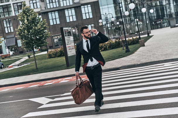 Confident businessman in full suit crossing street on zebra  - Foto, immagini