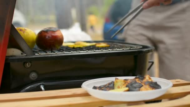Hořel bramborové lupínky a vařená jablka closeup během rodinné grilování gril venku - Záběry, video