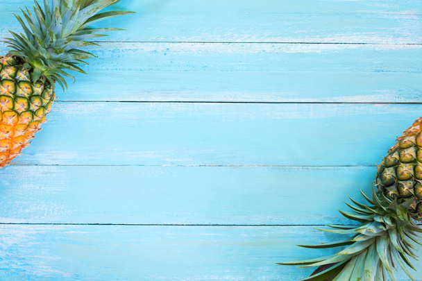 Piña tropical sobre tabla de madera de color azul. marco diseño verano vacaciones fondo concepto
. - Foto, Imagen