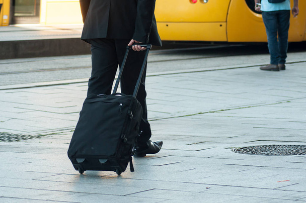 closeup of business man walking with suitcase in front of the train station - Φωτογραφία, εικόνα