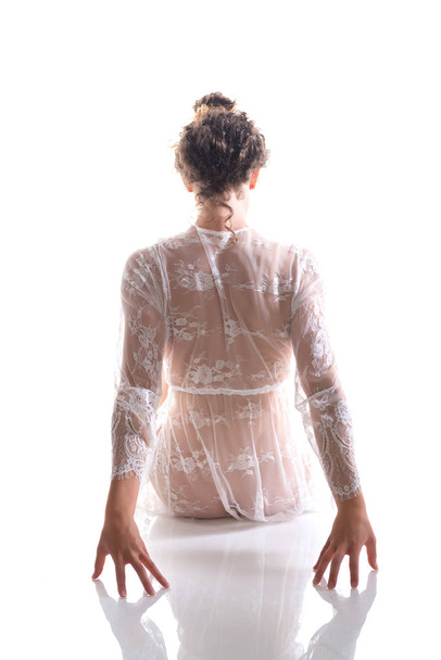 Tall slim brunette in a sheer white lace wrap - 写真・画像