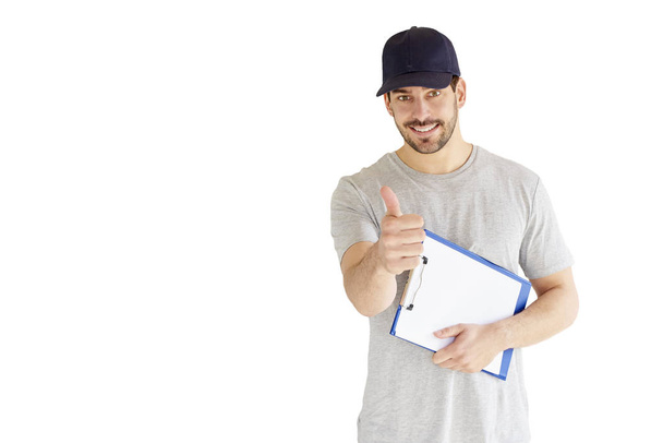 Portrait of young construction worker holding clipboard in his hand and giving thumbs up while standing at isolated white background.  - Foto, Imagen