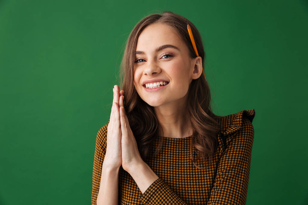 Image of cheerful young woman standing isolated over green background gesturing with hands. - Zdjęcie, obraz