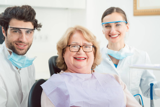 Dentistes et patients en chirurgie regardant la caméra
 - Photo, image