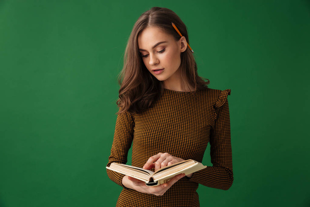 Állandó elszigetelt fölött zöld háttér könyvével csodálatos fiatal nő képe. - Fotó, kép