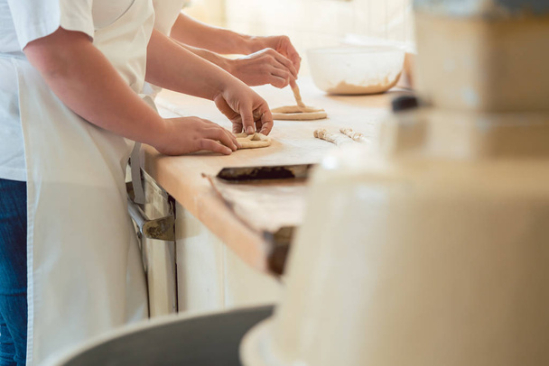 Close-up on baker in bakery forming pretzel bread - 写真・画像