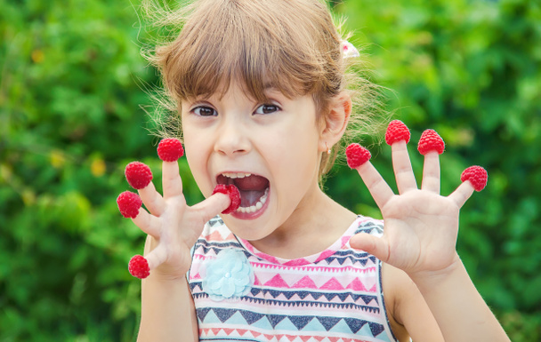 The child eats homemade raspberries. Selective focus. - Photo, Image
