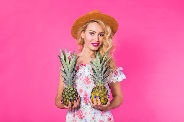 Щаслива молода жінка тримає ананас на рожевому тлі. Концепція літа, дієти та відпустки
 - Фото, зображення