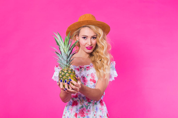 Fashion portrait young beautiful woman with pineapple over pink background - Foto, Imagen