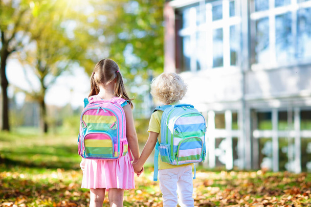 Children go back to school. Start of new school year after summer vacation. Boy and girl with backpack and books on first school day. Beginning of class. Education for kindergarten and preschool kids. - Fotó, kép