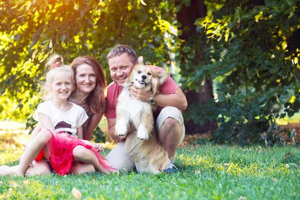 happy fun holidays - family and corgi fluffy  on the lawn on a sunny summer da - Photo, Image