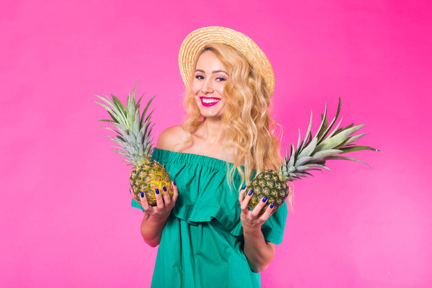 Mode portret jonge mooie vrouw met ananas op roze achtergrond - Foto, afbeelding