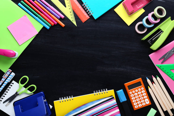 School supplies on blackboard background - Фото, изображение
