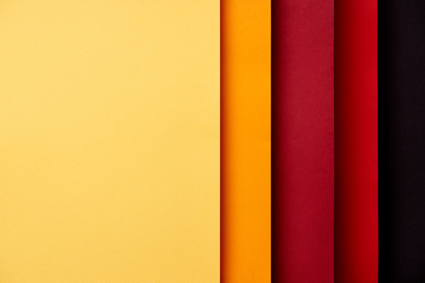 Pattern of overlapping paper sheets in red and yellow tones - Фото, изображение