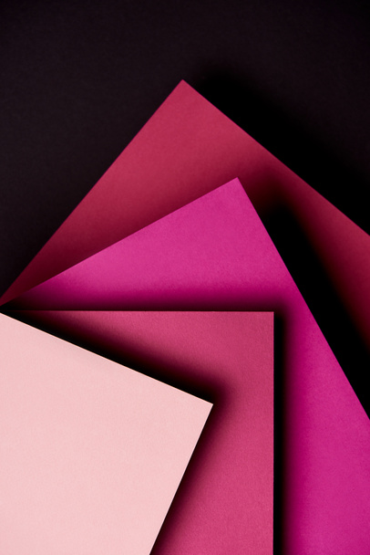 Paper sheets in pink tones on black background - Foto, imagen