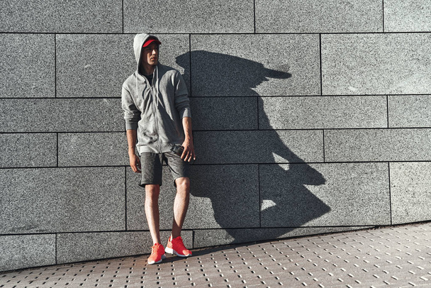 young man in sports clothing at stone wall - Fotoğraf, Görsel