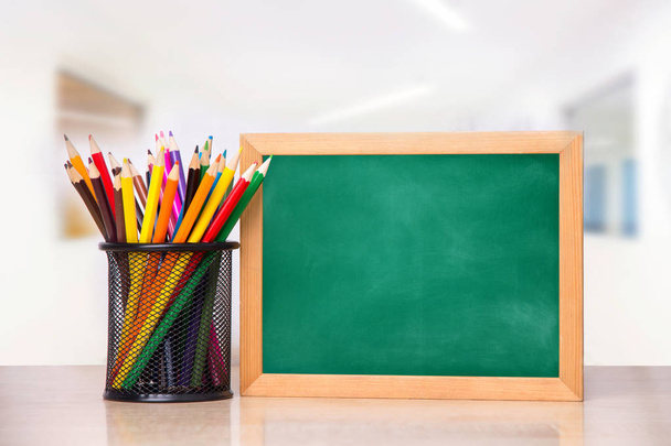 Lasi kyniä ja koulun hallituksen kirjallisesti puinen pöytä
 - Valokuva, kuva