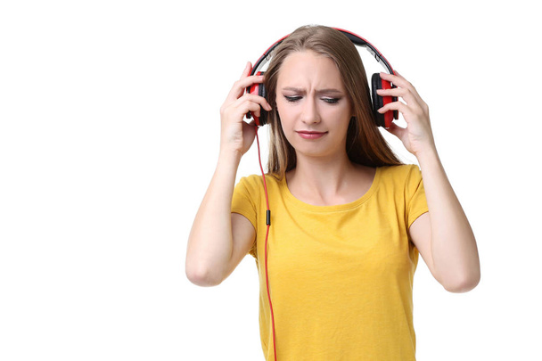 Young woman with headphones on white background - Φωτογραφία, εικόνα
